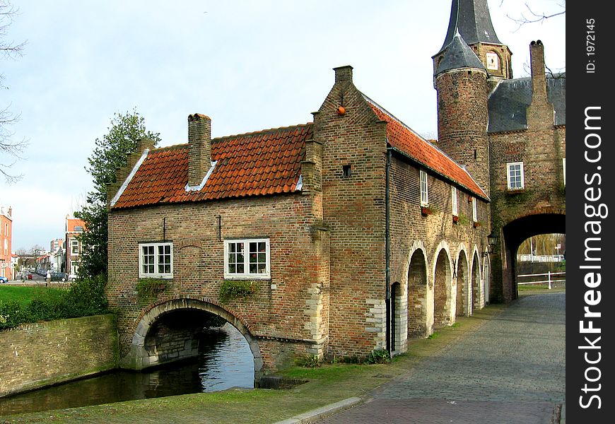 Ancient Gate. Canal. Stone building under the canal. Delft.