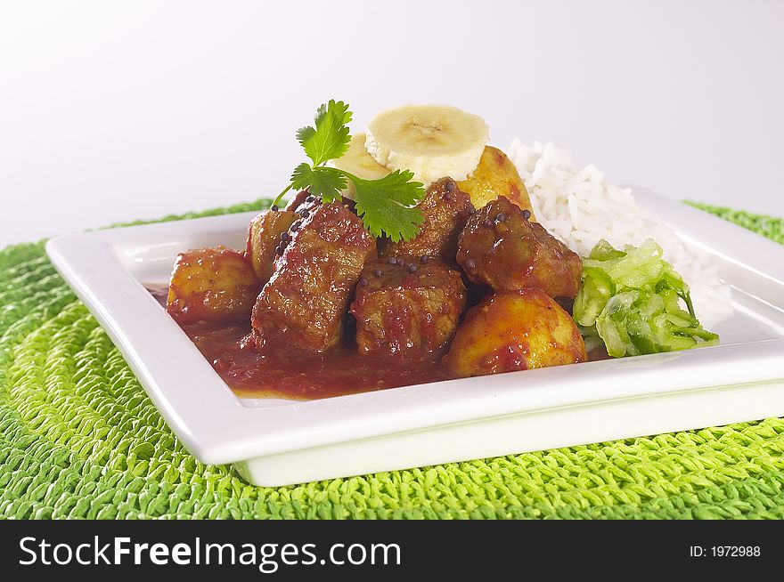 Curry and Rice on white plate with green mat