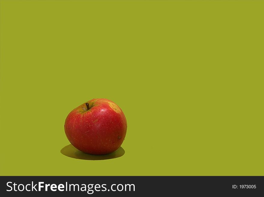 A photo of a healthy apple on green background - with lots of space for text.