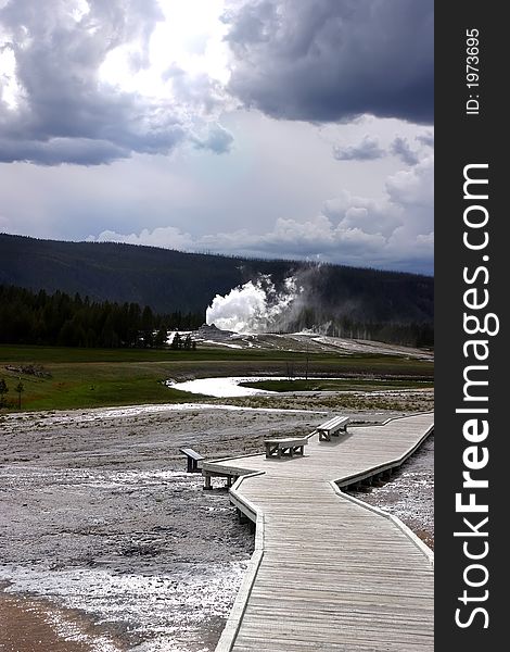 Geyser on walking trail in Yellowstone from long range. Geyser on walking trail in Yellowstone from long range