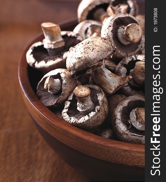 Portabella mushrooms in a wooden brown bowl. Portabella mushrooms in a wooden brown bowl