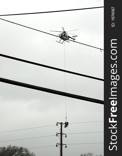 workers hanging from helicopter wiring cables. workers hanging from helicopter wiring cables