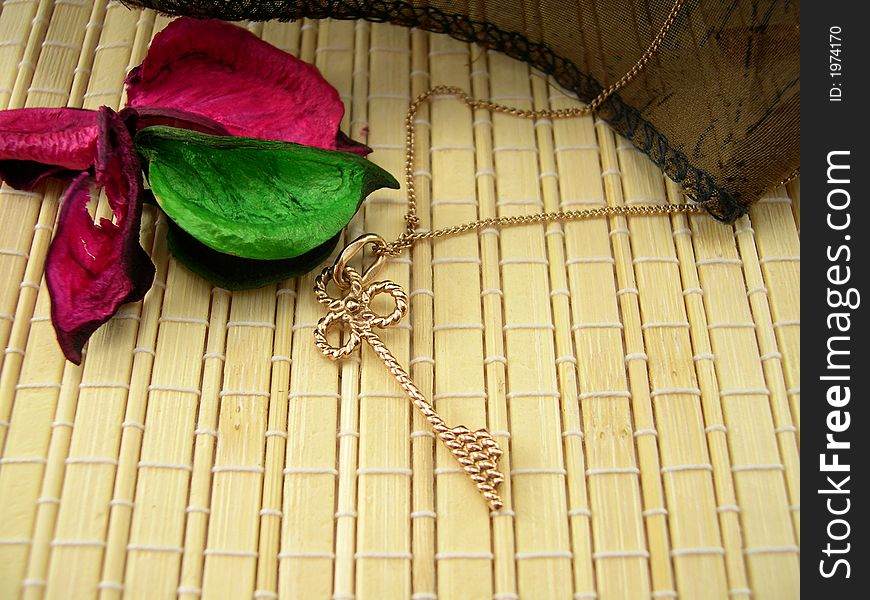 Beautiful gold chain with a key on a bamboo napkin
