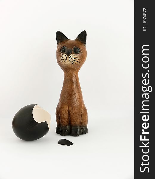 The wooden cat and a broken egg. The wooden cat and a broken egg