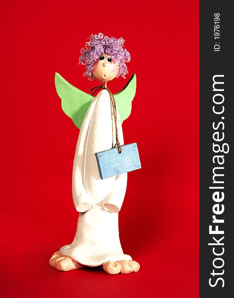 Ceramic angel isolated on red background