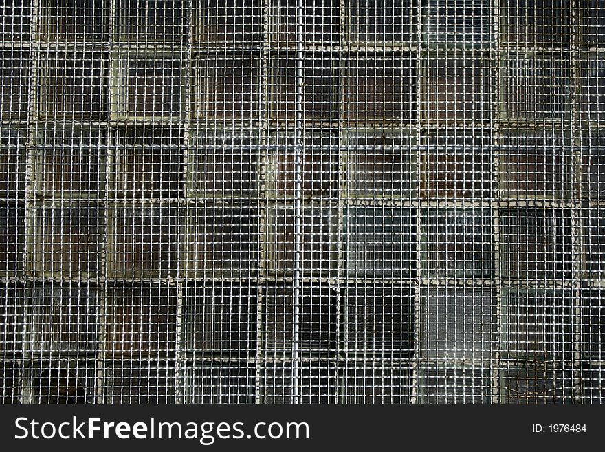 Rusty metal net covering the window. Rusty metal net covering the window.