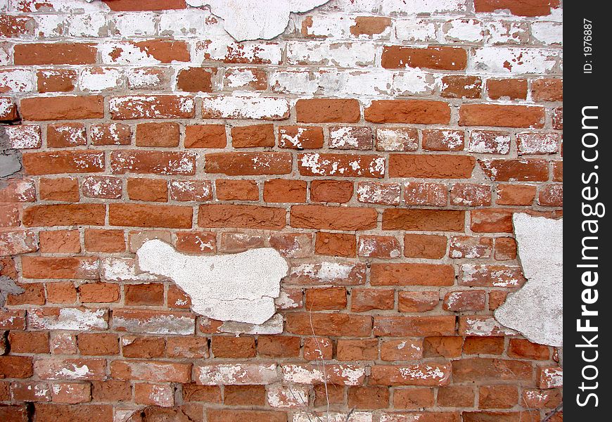 Wall from brick with remainder of the plaster