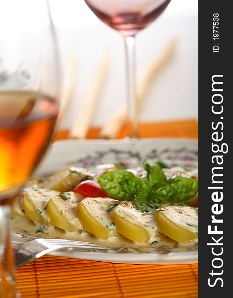 Oven potatoes with dressing and herbs served with wine. Oven potatoes with dressing and herbs served with wine