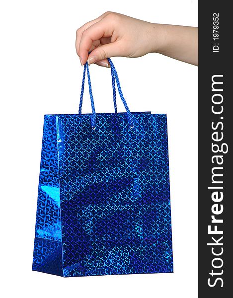 Blue package with a gift in a hand on a white background