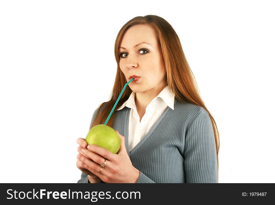 The girl holds in a mouth a tubule for juice which is inserted into an apple. The girl holds in a mouth a tubule for juice which is inserted into an apple