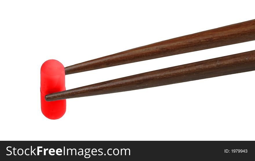 Two chopsticks holding a red capsule-isolated over white background. Two chopsticks holding a red capsule-isolated over white background