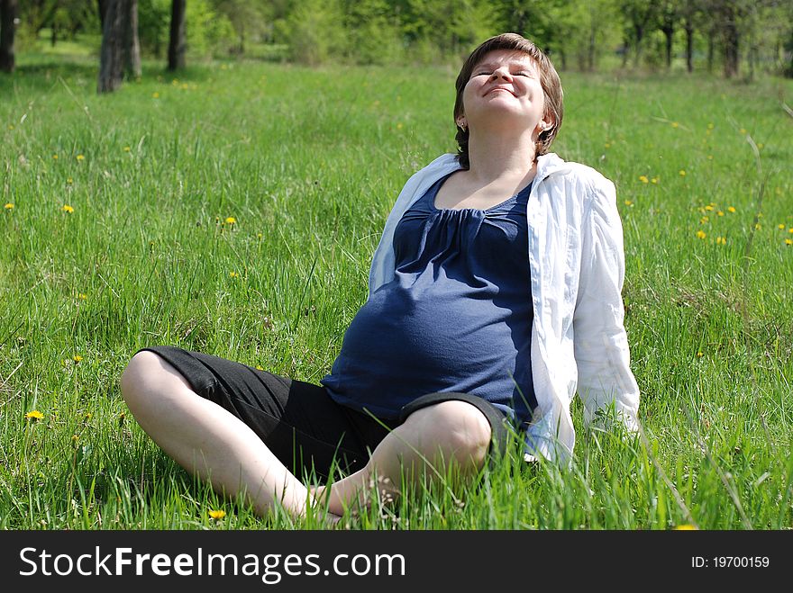 Sunny spring day. A pregnant woman relaxing outdoors. Sunny spring day. A pregnant woman relaxing outdoors