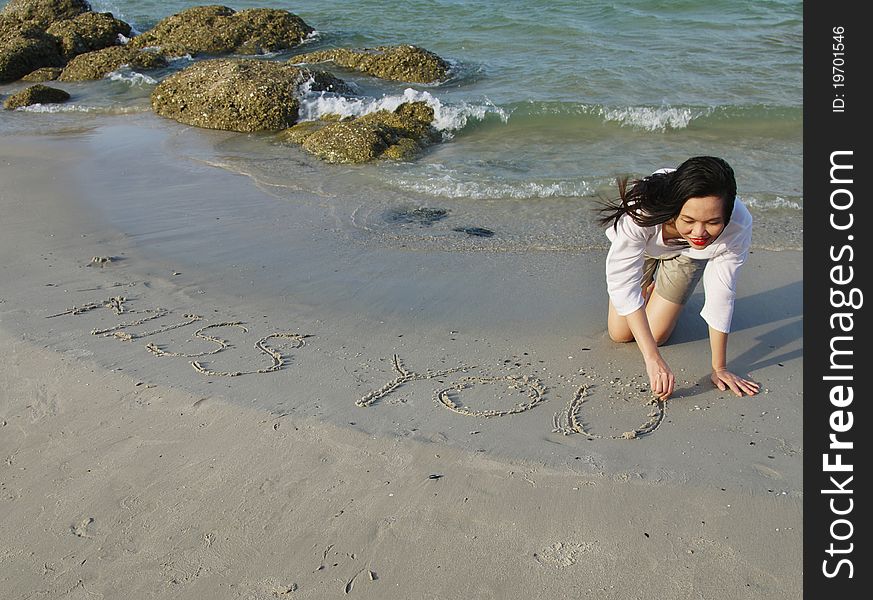 Young woman writing on sand beach