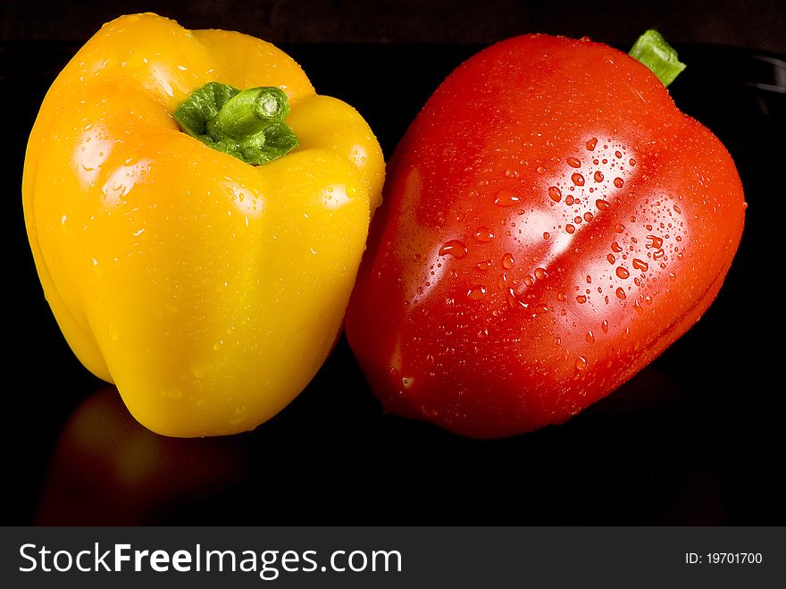 Yellow and red peppers on a black background