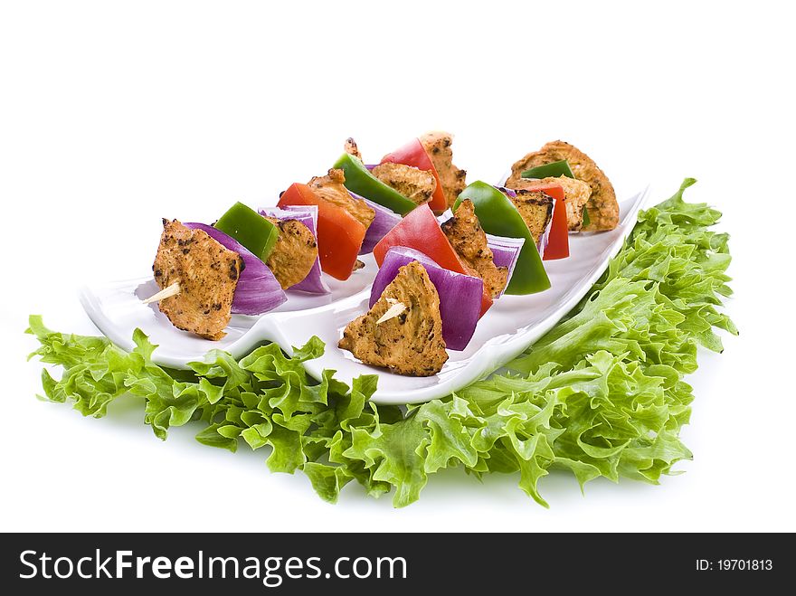 Skewers with chicken and vegetables on the plate - isolated. Skewers with chicken and vegetables on the plate - isolated