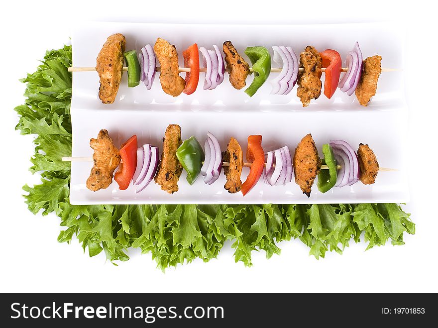 Skewers with chicken and vegetables on the plate - isolated. Skewers with chicken and vegetables on the plate - isolated