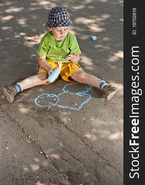 Boy drawing with chalk on asphalt