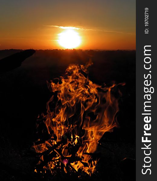 Evening fire flames against sunset horizon sky