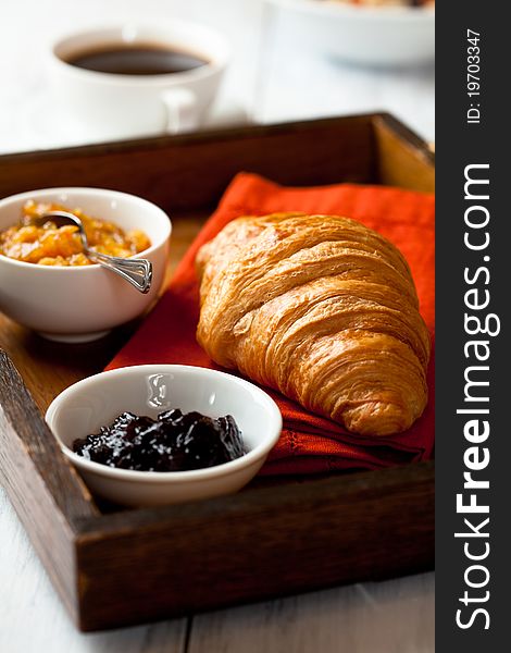 Closeup of french croissant on a rustic wooden tray. Closeup of french croissant on a rustic wooden tray
