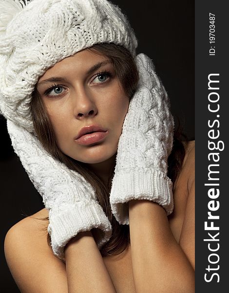 Young  naked woman in knit white mittens and cap