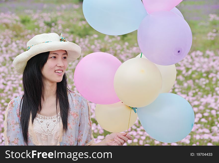 A girl is smiling with balloons in hand. A girl is smiling with balloons in hand