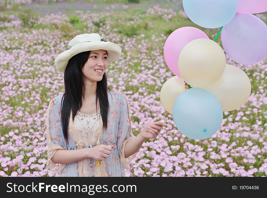 A girl is smiling with balloons in hand. A girl is smiling with balloons in hand
