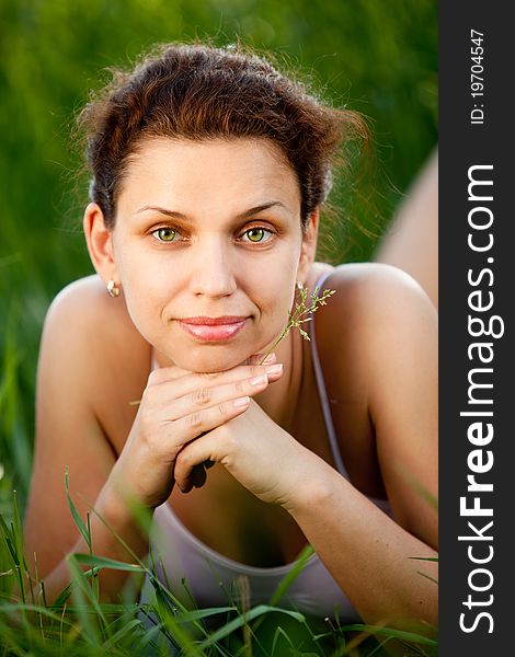 Beautiful smiling girl lying in the grass in nature. Beautiful smiling girl lying in the grass in nature.