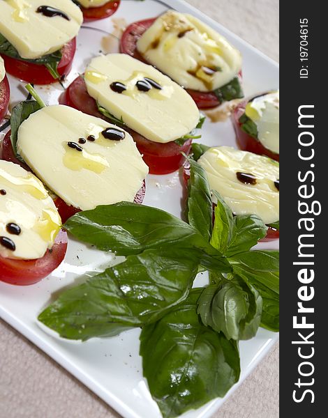 Dish of tomatos with mozzarella, basil, olive oil and balsamic vinigar. Dish of tomatos with mozzarella, basil, olive oil and balsamic vinigar.