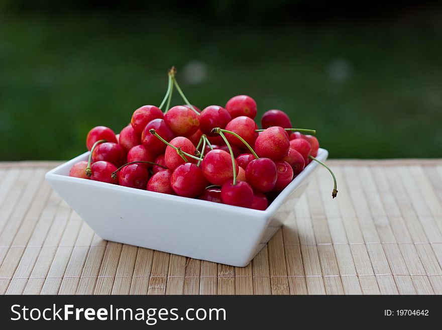 Cherries in a bowl shot outside. Cherries in a bowl shot outside