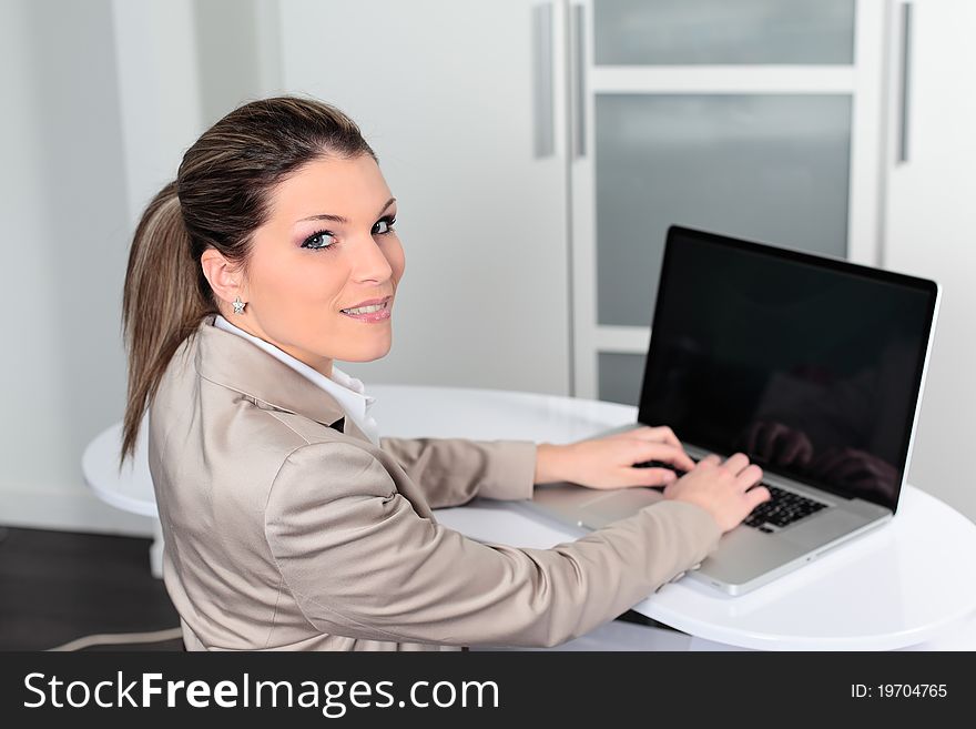 Young businesswoman with computer in office