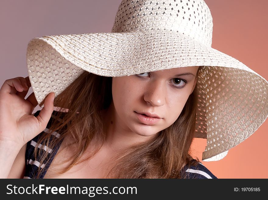 Portrait of a girl wearing a hat with a red background