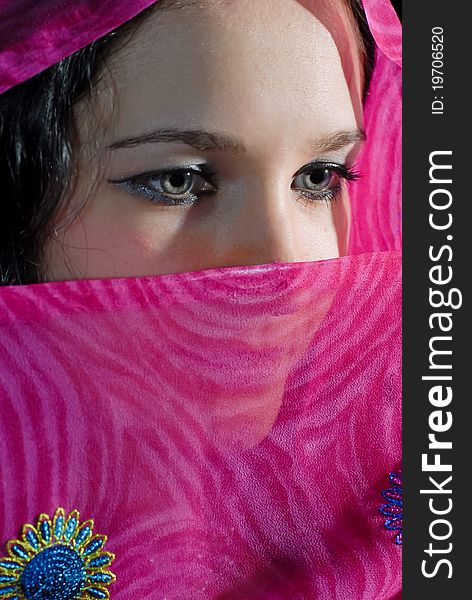 Young woman hiding part of her face under pink shawl. Young woman hiding part of her face under pink shawl