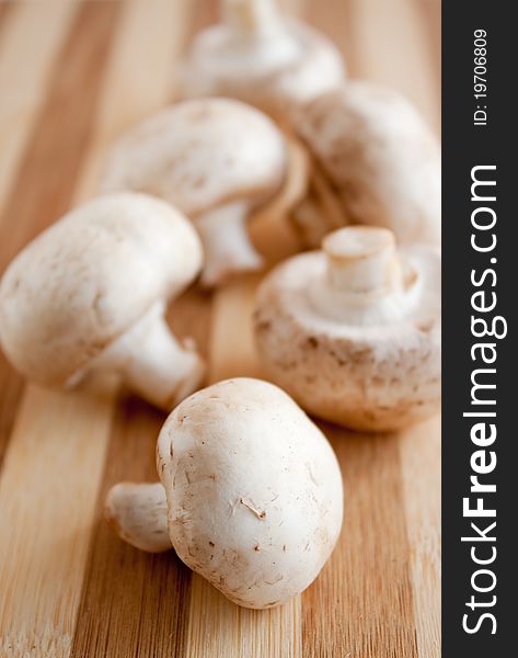 a pile of chestnut mushrooms  on a wooden brown board