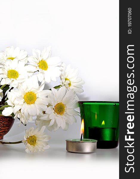 Simple white daisies and two candles with isolated white background