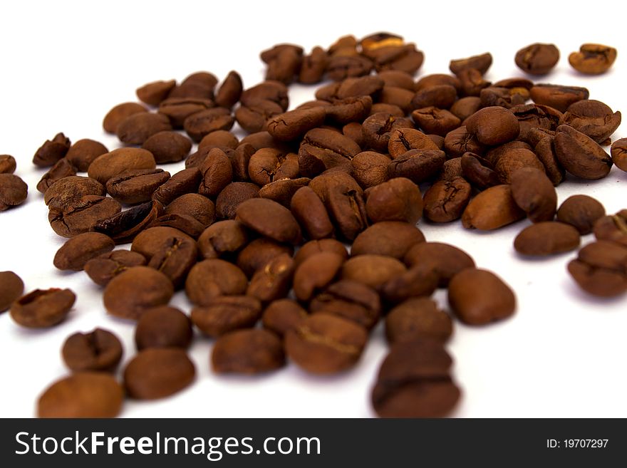 Scattered grains of black coffee isolated on white