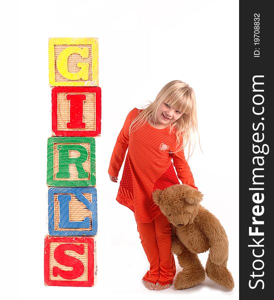 Elementary student with wooden blocks and a teddy bear