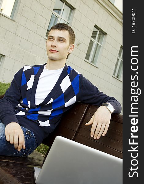 Close-up of a young male student with a laptop on campus. Close-up of a young male student with a laptop on campus