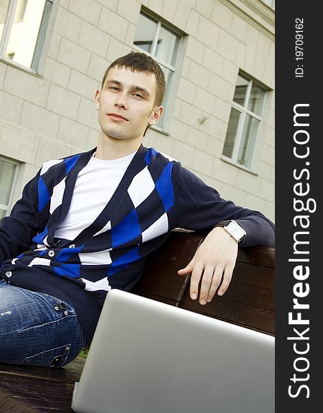 Close-up of a young male student with a laptop on campus. Close-up of a young male student with a laptop on campus