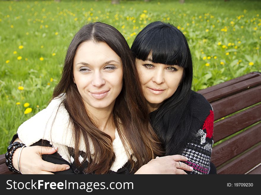 Portrait of smiling mother and teenage daughter hugging in the park happy. Portrait of smiling mother and teenage daughter hugging in the park happy