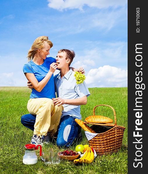 Happy young couple having a picnic outdoor on a summer day. Happy young couple having a picnic outdoor on a summer day