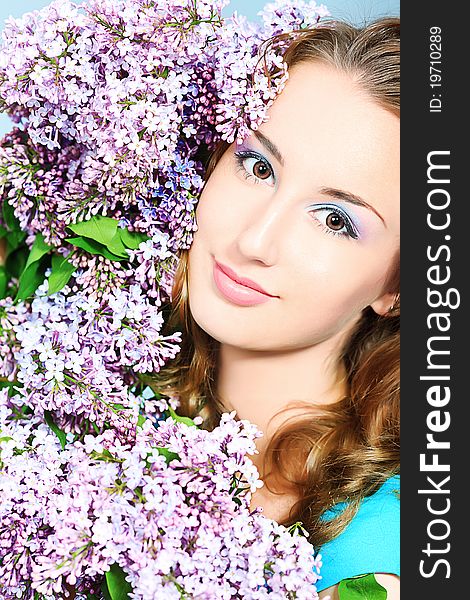 Portrait of a beautiful spring girl in lilac flowers.