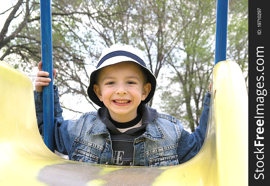 Happy boy wearing a yellow slide. Happy boy wearing a yellow slide