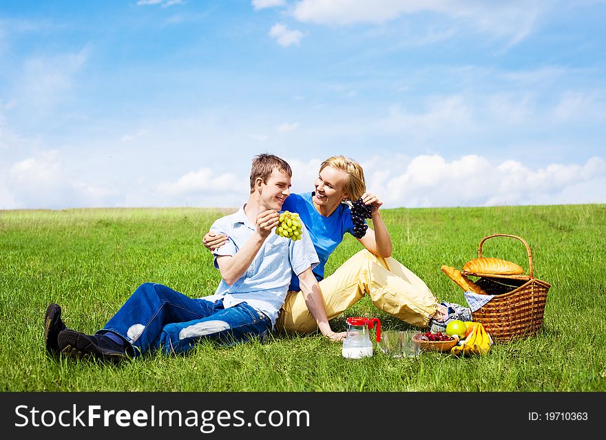 Happy young couple having a picnic outdoor on a summer day. Happy young couple having a picnic outdoor on a summer day