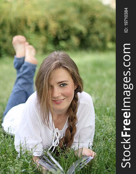 Portrait of the beautiful smiling girl on the grass