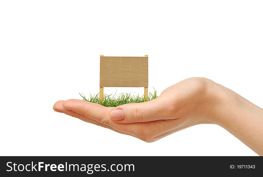 Cardboard sign with green grass on human hand on white