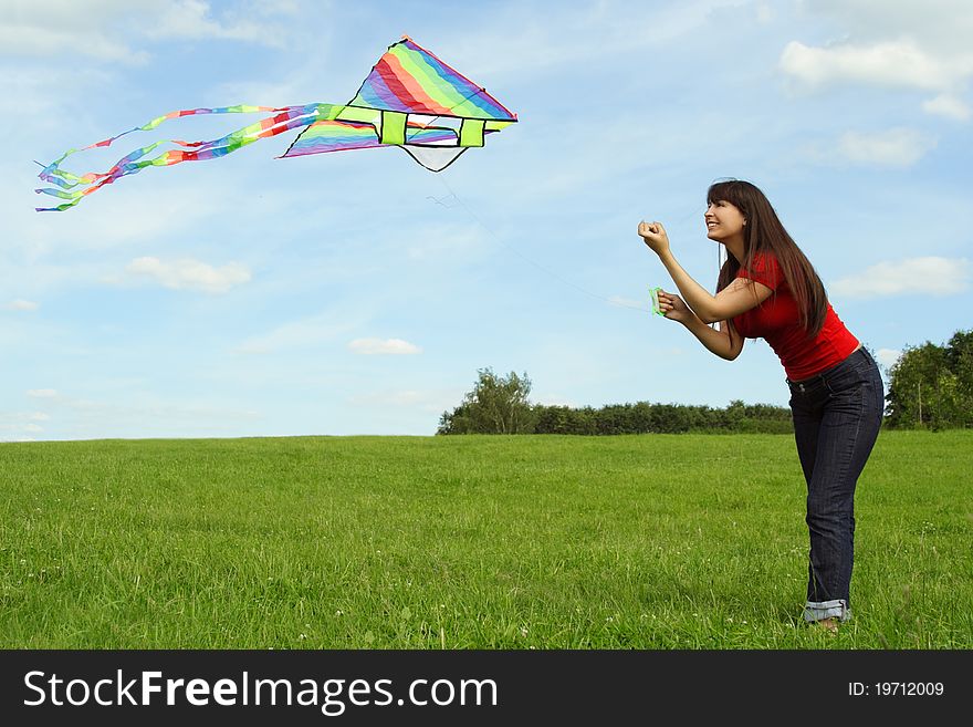 Girl flying kite on summer meadow