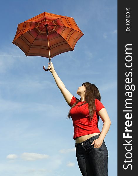 Young beautiful girl in red shirt and with long brunette hair holding umbrella on stretch out hand. Young beautiful girl in red shirt and with long brunette hair holding umbrella on stretch out hand