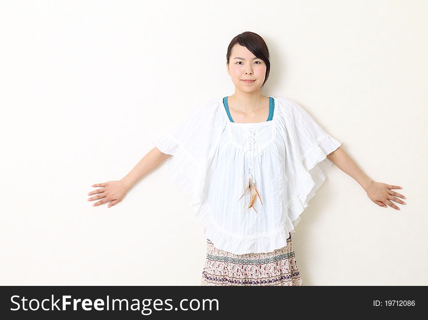 Young beautiful asian woman leaning against wall