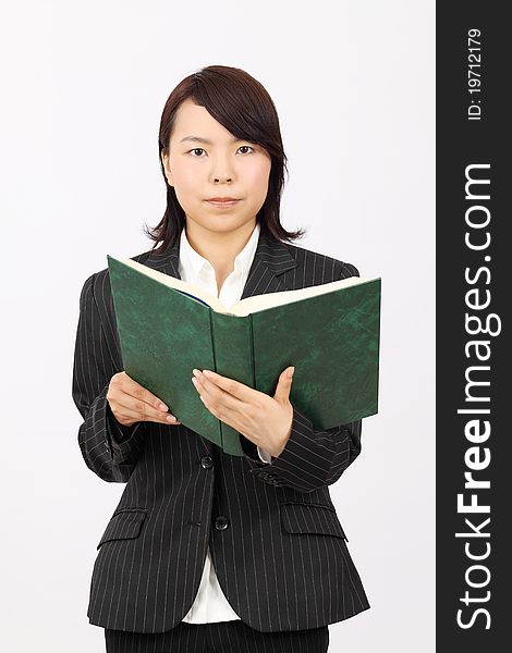 Young japanese business woman holding a book. Young japanese business woman holding a book