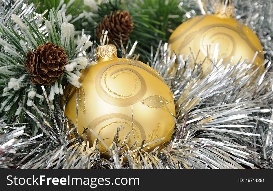 Christmas balls against the backdrop of tinsel with pine branches and cones. Christmas balls against the backdrop of tinsel with pine branches and cones